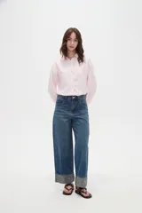 Pantalón jean de corte baggy y tiro medio, con diseño amplio y dobladillo vuelto que deja ver un detalle estampado en el interior.