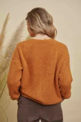 Saco tejido de punto color naranja, con escote redondo, cierre frontal con botones y mangas largas.