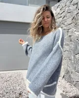 Sweater de tejido de punto en color gris con detalles de bordes en color blanco, de corte holgado y mangas largas.