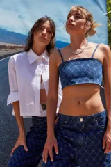 Jean de tiro bajo y corte oversize, confeccionado en denim azul con grabado láser de monograma en patrón de rombos. Presenta avíos metálicos y diseño de pierna ancha.