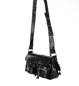 Cartera de hombro negra de charol, con solapa frontal asegurada con hebilla y correa ajustable. Presenta dos bolsillos frontales con cierres y ojales metálicos, además de detalles de cordones con ojales en los laterales. Incluye un dije metálico con las letras 'R' y 'O' entrelazadas.