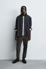 Pantalón tipo jogger de corte slim fit, confeccionado en tejido de algodón con elasticidad. Presenta cintura elástica ajustable con cordón, bolsillos frontales, bolsillos traseros de vivo y bajos con puños elásticos.