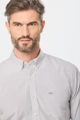 Camisa de manga larga a cuadros pequeños en tonos celeste y blanco, con bolsillo en el pecho y cuello abotonado. Corte slim fit hasta talle XL, a partir de XL classic fit.
