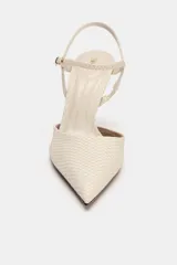Zapato de tacón destalonado color crudo con textura en relieve efecto piel de serpiente, punta fina, tacón alto fino y tira ajustable con hebilla en el tobillo.