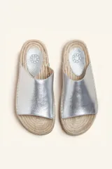 Sandalias tipo alpargata con capellada de cuero charol color bordó y planta tejida en fibra natural de yute. Presentan costuras a mano en color blanco y suela de goma.