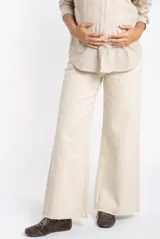 Pantalón de jean color beige, de corte wide leg con botamanga desflecada y tiro medio, diseñado especialmente para maternidad.