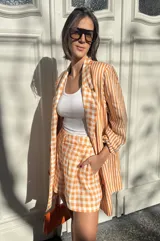Short sastrero de lino con estampado de rayas verticales naranjas y blancas, corte holgado.