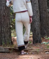 Pantalón jogger de punto color blanco marfil, confeccionado en lana merino, con tiro alto, cintura elástica y diseño con bloque de color marrón y detalles geométricos en el bajo.