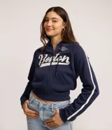 Campera crop azul marino de felpa, con cierre frontal y capucha. Cuenta con mangas largas con franjas blancas laterales, bolsillos tipo canguro y estampa con la inscripción 'Boston' y detalles gráficos en el pecho.