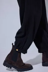 Pantalón tipo bombachita con pinzas que aportan volumen, confeccionado en Tencel. Presenta cierre frontal con botones dorados, bolsillos delanteros y ruedo ajustable mediante botón dorado.