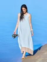 Vestido largo sin mangas color beige con ruedo verde, de corte amplio y estilo casual.