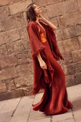 Vestido largo con pechera de cuero metalizado y falda tejida con hilo de lurex brillante. Presenta un diseño de cuello halter y corte fluido.