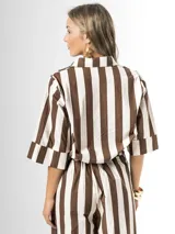 Camisa de algodón con estampa a rayas en colores marrón y blanco, de corte holgado, mangas tres cuartos y cuello camisero clásico.