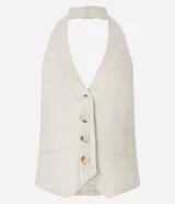 Chaleco color crudo confeccionado en viscolino, con escote halter, cierre frontal con botones, bolsillos delanteros falsos y bajo en V.