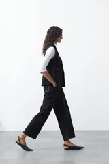 Pantalón de corte recto y tiro medio, confeccionado en algodón con elastano. Presenta costuras a contratono en color blanco que resaltan los recortes delanteros y el diseño de la prenda, aportando un estilo utilitario.