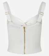 Top cropped blanco de tirantes anchos, confeccionado en tejido de punto texturizado, con escote en V y detalle de nudo o torcido en el centro del busto.