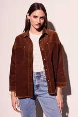 Sobrecamisa de pana color rojo, con cierre frontal de botones, bolsillos delanteros con solapa y ruedo desflecado.