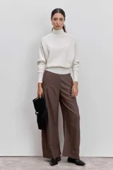 Sweater de punto color negro, con cuello alto y mangas largas de corte raglán.