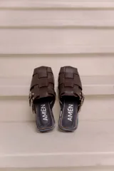 Suecos de cuero vacuno color marrón, marca Amén, con diseño de tiras entrelazadas, puntera cuadrada y hebilla metálica ajustable en el lateral.