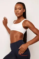 Top deportivo negro con tirantes medianos y espalda baja, confeccionado en poliamida de alto rendimiento. Cuenta con inscripciones estampadas en el frente con la frase "Performance Pro" y detalles gráficos.