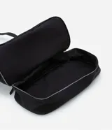 Bolso tipo maleta de tamaño grande en color negro, confeccionado en una mezcla de poliuretano y poliéster. Presenta cierres de cremallera plateados contrastantes, un bolsillo frontal con cierre y un compartimento inferior independiente con cierre. Incluye asas de mano dobles y una correa de hombro larga, ajustable y extraíble.