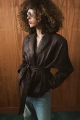 Chaqueta de Zara Woman Collection confeccionada en tejido efecto piel con textura granulada. Presenta cuello solapa, manga larga y cierre frontal con cinturón ajustable mediante lazada. Incluye forro interior.
