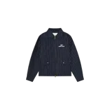 Campera Eme Studios modelo Siroq Striped Navy, confeccionada en tejido azul marino con diseño de rayas diplomáticas blancas. Cuenta con cuello camisero, cierre frontal de cremallera metálica de doble sentido, dos bolsillos frontales con solapa y botones dorados, y logo bordado en el pecho.