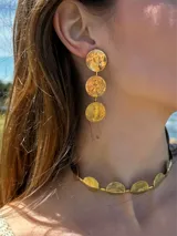 Aros colgantes dorados con tres círculos texturizados.
