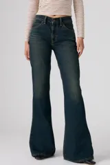 Jeans de denim azul oscuro con lavado vintage, tiro alto y corte acampanado.