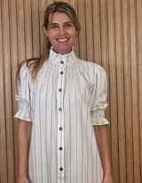 Vestido midi marrón con textura sutil, cuello alto fruncido, cierre frontal con botones y mangas cortas abullonadas con elástico.