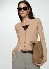 Cardigan de punto fino en color beige, con cuello en pico, cierre frontal con botones y diseño recto de manga larga.