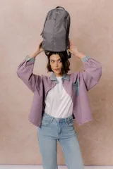 Mochila compacta de color beige, con compartimento principal con cierre, bolsillos laterales y bolsillo frontal con cierre oculto. Cuenta con correas regulables y acolchonadas y asa superior.