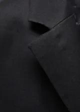 Americana negra de lino y viscosa, con cuello de solapa, cierre frontal con botón, dos bolsillos laterales con solapa, mangas largas con puños abotonados y forro interior.