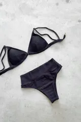 Conjunto de bikini de dos piezas con efecto brillante y estampado tipo tie-dye en tonos azules. El top es de estilo triángulo con breteles regulables y cierre de gancho en la espalda. La bombacha es de tiro alto y corte vedetina.