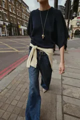 Jersey de punto con cuello redondo y mangas anchas tipo murciélago. Presenta un diseño de corte holgado con terminaciones en rib a tono en el cuello, puños y bajo.