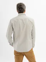 Camisa de corte regular confeccionada en tejido oxford, color azul claro. Presenta cuello con botones, cierre frontal abotonado, mangas largas con puños y un bolsillo frontal en el pecho.