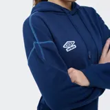 Canguro Umbro azul marino del Club Nacional de Football con capucha, cordones de ajuste, bolsillo tipo canguro y costuras decorativas visibles en contraste. Presenta el logo de Umbro y el escudo del club bordados en el pecho.