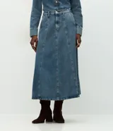 Pollera midi de corte evasé confeccionada en denim de algodón. Presenta cintura alta con pasantes, cierre frontal con botón y cremallera, bolsillos funcionales y costuras verticales decorativas que estructuran la prenda.