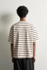 Camiseta de manga corta a rayas horizontales azul marino y blancas, de corte regular fit, con cuello panadero y cierre frontal de botones.