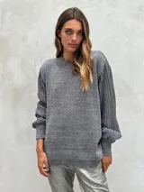 Sweater de punto color gris oscuro con hilos de lurex plateados, cuello redondo y mangas largas abullonadas con puños ajustados.