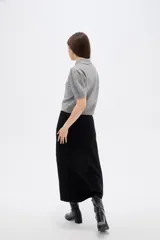 Saco de punto gris con cuello tipo camisa, manga corta y cierre frontal con botones. Presenta un delicado bordado de flores blancas en la parte superior delantera.