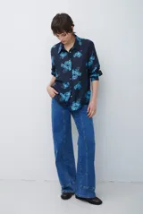 Jean de corte recto y tiro medio, color azul lavado, con costuras verticales decorativas en el frente y ruedo con dobladillo ancho.