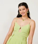 Blusa cropped color verde claro de lino con tirantes finos, escote en V con abertura en el pecho y ribete en color crema.