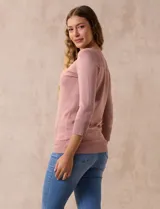 Buzo color rosa de tejido combinado con detalle de botones en las mangas y cuello redondo.