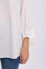 Camisa blanca de manga larga abullonada estilo globo, con cuello camisero, cierre frontal parcial de botones y diseño holgado.