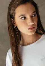 Aro tipo argolla de bronce con dije colgante en forma de letra.