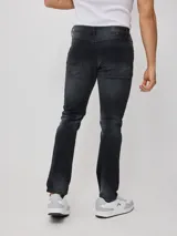 Pantalón jean negro de corte slim fit y cintura media. Confeccionado en 83% algodón, 15% poliéster y 2% elastano.