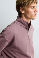 Sudadera de corte boxy fit con cuello subido y cierre frontal de cremallera. Presenta mangas largas, acabado efecto lavado y puños y ruedo en rib.