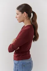 Remera color beige de mangas largas con cuello redondo y puños blancos en contraste.