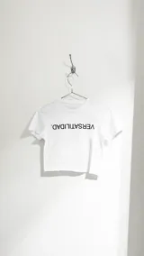 Crop top blanco con estampa de la palabra 'VERSATILIDAD' en negro.
